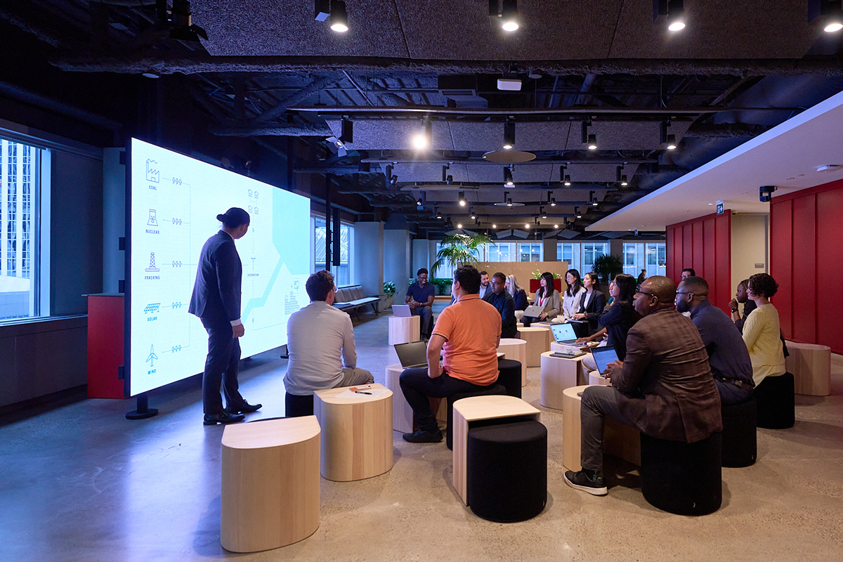 Morningstar employees attending a presentation in a collaborative workspace with a large screen display.