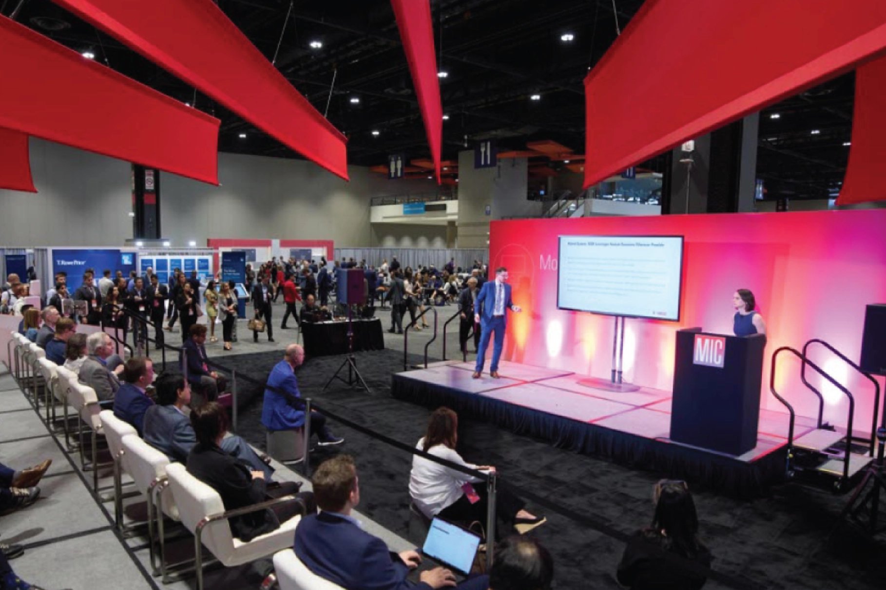 Wide-angle view of a presenter at the Morningstar Investment Conference on a small stage in front of an audience.