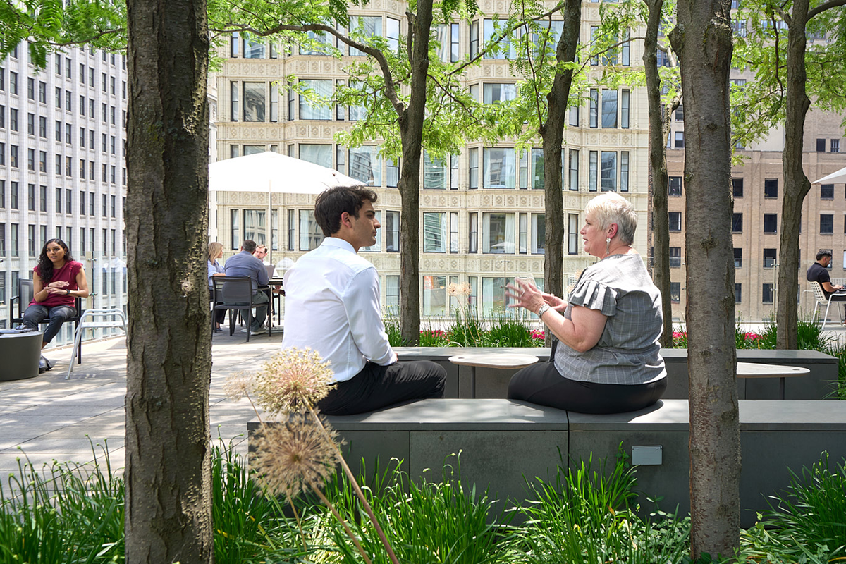 Two Morningstar employees meeting and talking in an outdoor courtyard workspace.