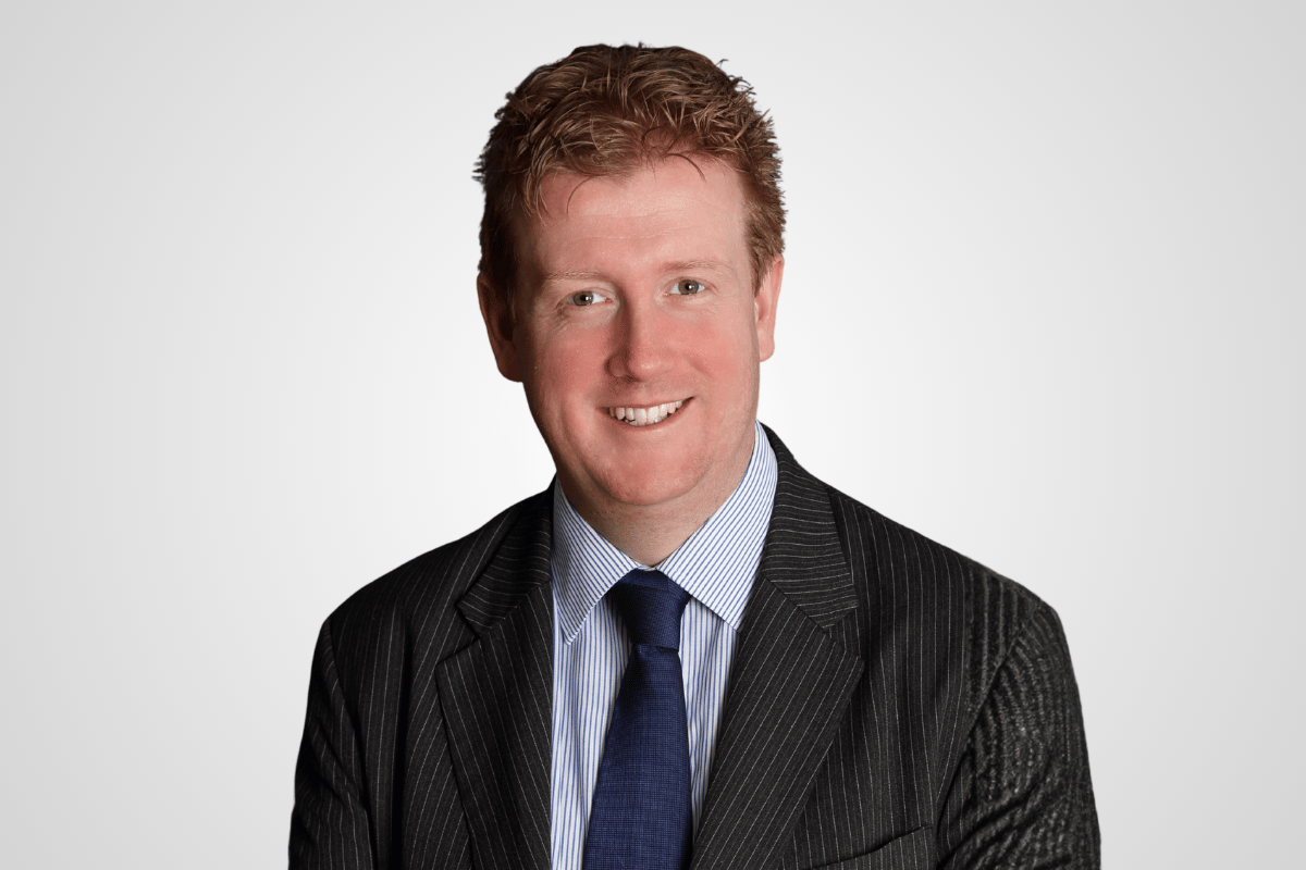 A professional portrait of Iain Perry.