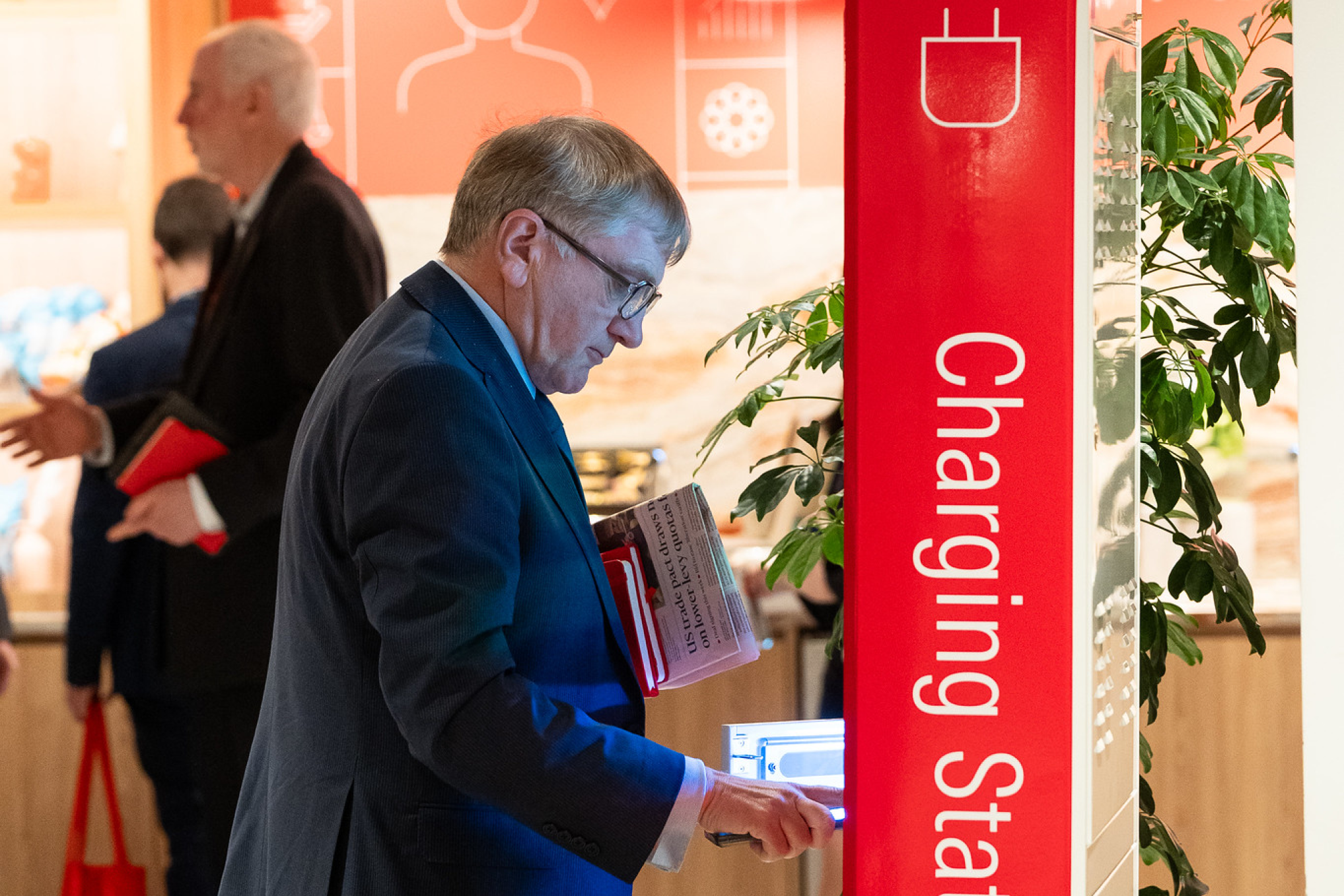 A gentlemen standing in front of a charging station.