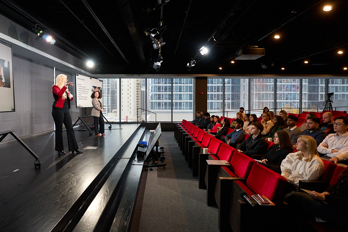 Morningstar employees attending a presentation in an auditorium led by colleagues on stage.